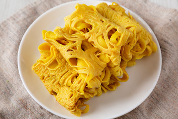 Homemade Net Crepe Roti Jala on a white plate, low angle view. Close-up.
