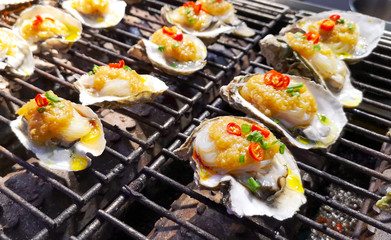 Shellfish in the shells is fried on a barbecue.