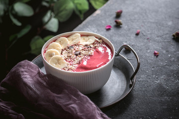 Raspberries smoothie bowl with fresh banana and granola