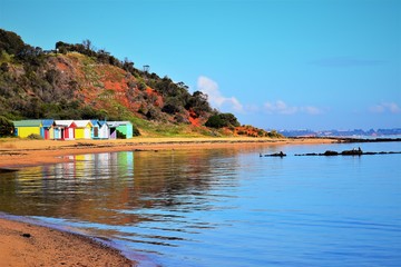 Fototapeta na wymiar Welcome tourists to colorful bathing boxes at Mornington Peninsula beach. Victoria. Australia