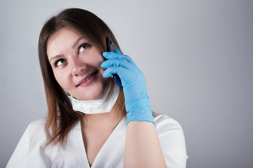 doctor, nurse talking on the phone. young doctor, paramedic accepts the call. young woman in gloves with special protection.