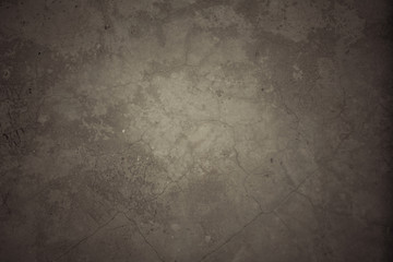 Grungy dark cement wall with cracking.          