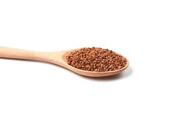 Dry buckwheat on wooden spoon isolated on white background.
