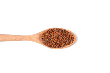 Dry buckwheat on wooden spoon isolated on white background.