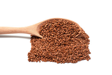 Dry buckwheat on wooden spoon isolated on white background.