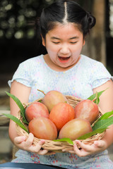 Cute Asian girl with delicious mangoes, A lovely Asian girl with delicious purple mango.