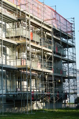 apartment house with scaffolding and protective net, for reconstruction and installation of insulation closeup, in detail