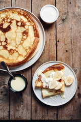 Thin pancakes, crepes with bananas and condensed milk.