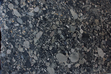 Natural Brazilian granite with pebbles of black and gray shades of color frozen in it is called Nero Marinace