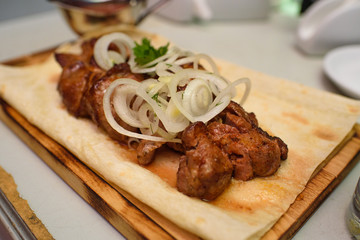Delicious juicy kebab for guests in the restaurant. A lot of tasty meat.