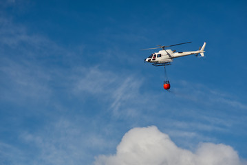 Fototapeta na wymiar Helikopter mit feuerlöschsack