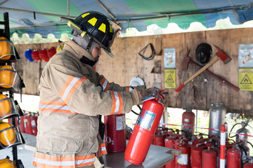 Asian fireman check Carbon Dioxide in fire extinguisher System ready In the event of a fire at fire...
