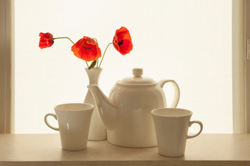 Morning coffee for two. . Coffee set and poppies on the windowsill