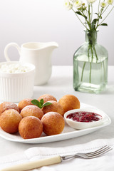 Beautiful breakfast. Cottage cheese donuts  balls  on a light background.
