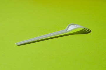 White plastic fork on a green background