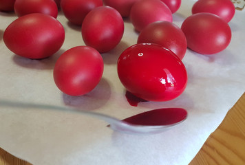 red easter eggs  while painting and polishing in the kitchen