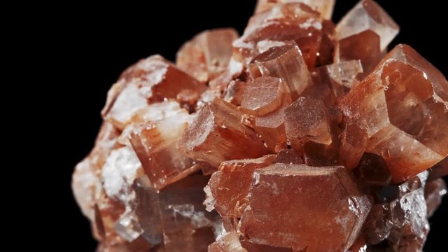 Seamlessly rotating a blood orange mineral Aragonite in front of black background