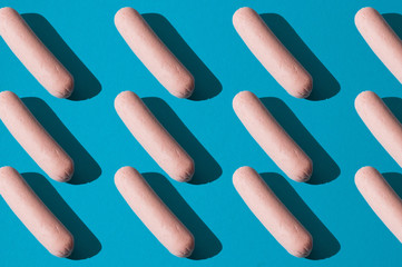 Pattern, a lot of raw sausages on a blue background