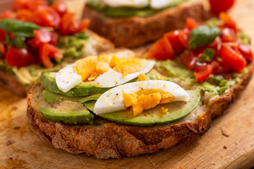 Mixed avocado toast with boiled eggs and tomatoes. Ideas for fast and nutritious dish. Summer food.