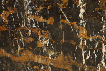 The slab of natural stone in brown with a pattern of yellow and white stripes is called Black and Gold