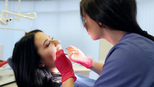 Female dentist doing dental treatment to her patient in clinic