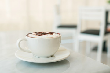 A cup of coffee on marble table in cafe.