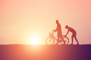Fototapeta na wymiar silhouette of couple driving bike happy time sunset