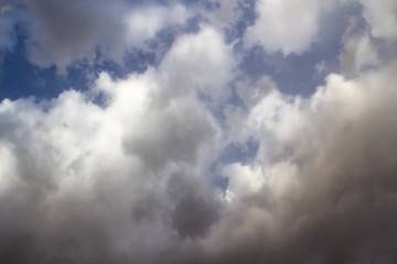 Clouds in the blue sky. A stunning gray sky. The storm is approaching. A beautiful clouds against the blue sky background. Amazing cloud pattern in the sky.