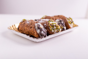 Cannoli siciliani. Typical Italian dessert from Sicily. Italian dessert with ricotta, chocolate chips and pistachios.