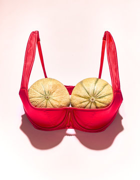 Two large melons in a pink bra, imitation of a large female breast.