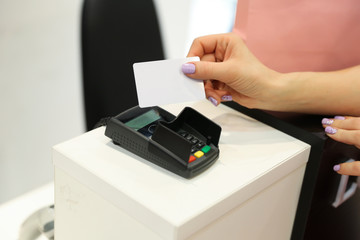 buyer's hand pays for the purchase with a contactless card in clothing store. non-cash payment via credit card.