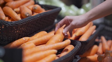 4k woman hand choosing carrots out of the basket shelf at super market grocery store shelf, fresh vegetable, lifestyle healthy eating, organic products, veggie food recipe menu, ingredient vitamin