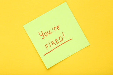 Text You Are Fired on paper on yellow background