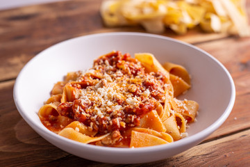 Tagliatelle with Bolognese ragu. Italian traditional tagliatelle dish with tomato and beef sauce. Rustic food, lunch with family.