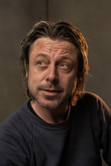 Studio portrait of a smiling man.