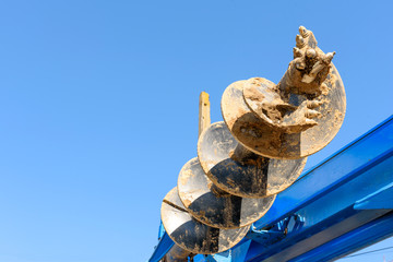 Tracer tractor with auger for soil drilling for piles installation