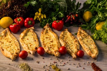 traditional cheese pita with vegetables on wooden background