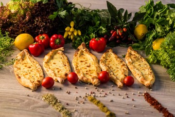 traditional cheese pita with vegetables on wooden background