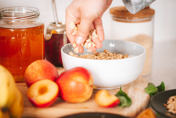 Hand preparing cereal for honey yogurt