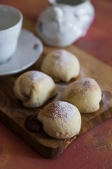 .chocolate filled cookies on colored background with teapot and cup