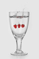 glass of ripe fruit splashing into water
