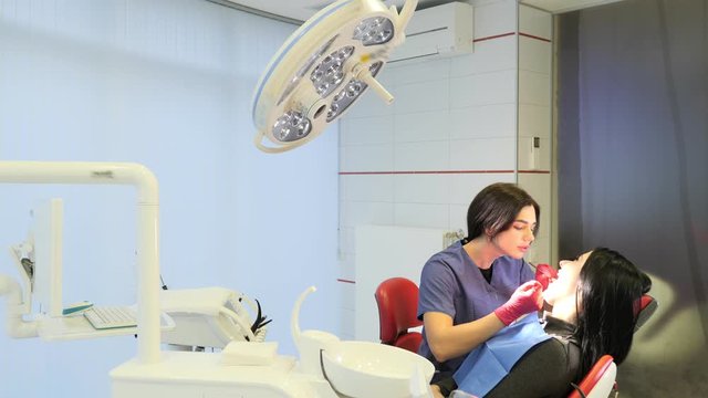 Female dentist doing dental treatment to her patient in clinic