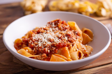 Tagliatelle with Bolognese ragu. Italian traditional tagliatelle dish with tomato and beef sauce. Rustic food, lunch with family.