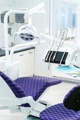 Interior of a modern dental clinic. The dentist's chair is ready to go. Special medical equipment in a white medical light