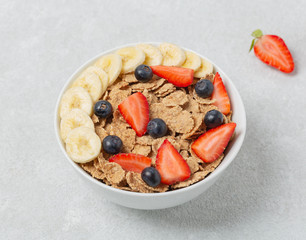 Multigrain wholegrain healthy cereal with banana and fresh berries strawberries and blueberries for Breakfast. Concept of delicious and healthy food.