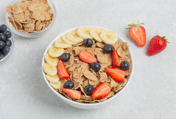 Multigrain wholegrain healthy cereal with banana and fresh berries strawberries and blueberries for Breakfast. Concept of delicious and healthy food.