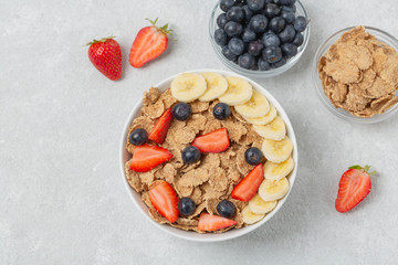 Multigrain wholegrain healthy cereal with banana and fresh berries strawberries and blueberries for Breakfast. Concept of delicious and healthy food.