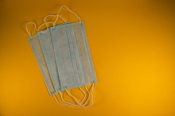 Medical surgical masks on yellow background