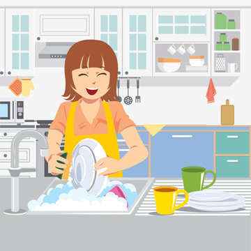 Beautiful smiling young woman washing the dishes in the kitchen.