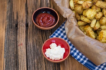 .baked potatoes with ketchup and mayonnaise on wooden background . food concept